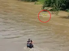 Il fermo immagine del video che riprende il vigile del fuoco nel disperato tentativo di raggiungere a nuoto i tre giovani