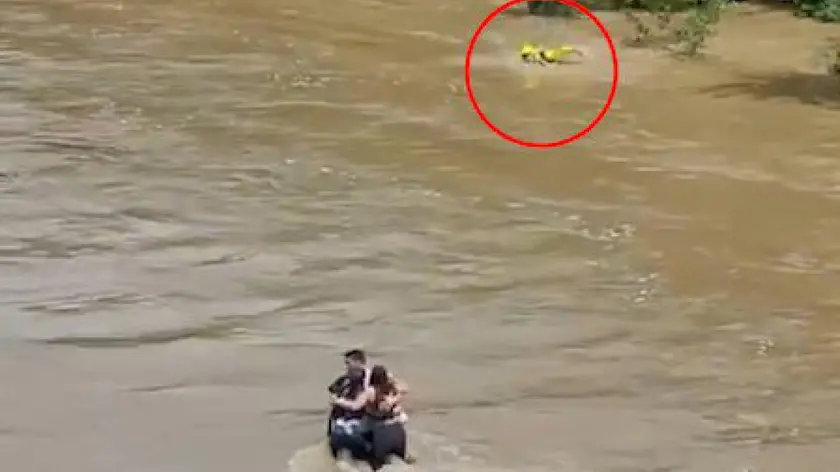 Il fermo immagine del video che riprende il vigile del fuoco nel disperato tentativo di raggiungere a nuoto i tre giovani