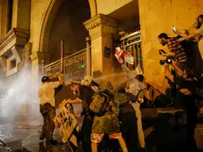 epa11313212 Georgian opposition party supporters try to break through the Georgian Parliament gate during a protest against a draft bill on 'foreign agents' in Tbilisi, Georgia, 01 May 2024. The Parliament of Georgia adopted the draft bill on 'foreign agents' in the second reading with 83 votes, 23 were against. Georgian Prime Minister Kobakhidze called on law enforcement officers to show maximum patience at protests against the 'foreign agents' law. According to Kobakhidze, the ruling Georgian Dream party will pass the bill despite the protests. EPA/DAVID MDZINARISHVILI