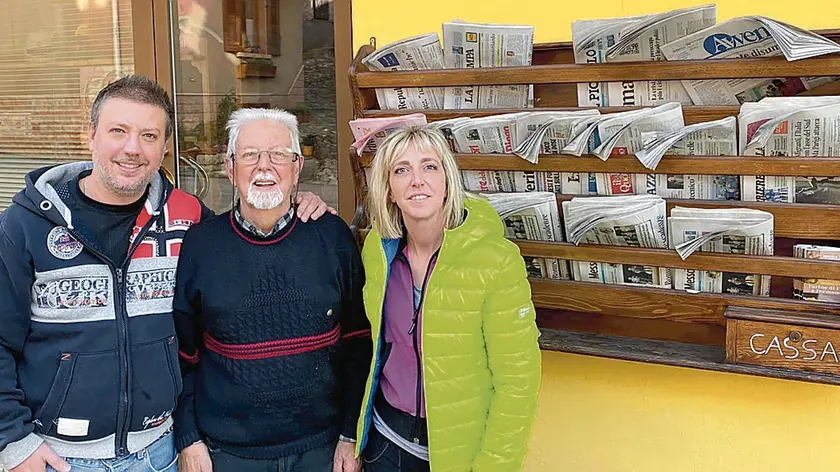 Stefano, Gustavo e Nicoletta Dassi con l’edicola self service di Cercivento alle loro spalle