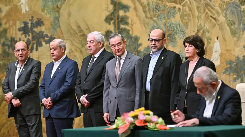 epa11492246 China's Foreign Minister Wang Yi (C) looks on during the signing of the 'Beijing declaration' at the Diaoyutai State Guesthouse in Beijing, China, 23 July 2024. China's Foreign Minister Wang Yi on 23 July hailed an agreement by 14 Palestinian groups to set up an 'interim national reconciliation government' to govern Gaza when the ongoing conflict is over. Palestinian groups including Hamas and Fatah met in Beijing this week in a renewed bid for reconciliation. EPA/PEDRO PARDO / POOL