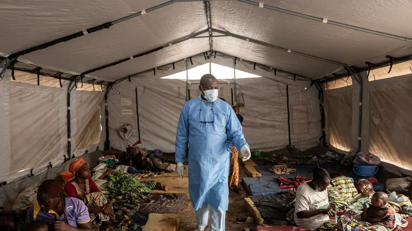 Un medico cammina tra i pazienti assistiti in Congo