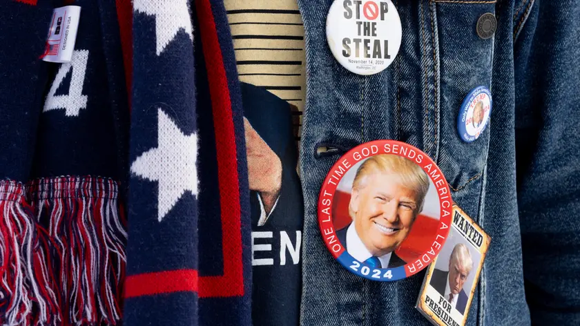 epa11097247 A supporter of former US President Donald J. Trump waits to enter a Trump campaign rally on the eve of the New Hampshire primary, in Laconia, New Hampshire, USA, 22 January 2024. The New Hampshire primary is held 23 January 2024 and is the second contest in the nominating process of the Republican presidential nomination. EPA/MICHAEL REYNOLDS
