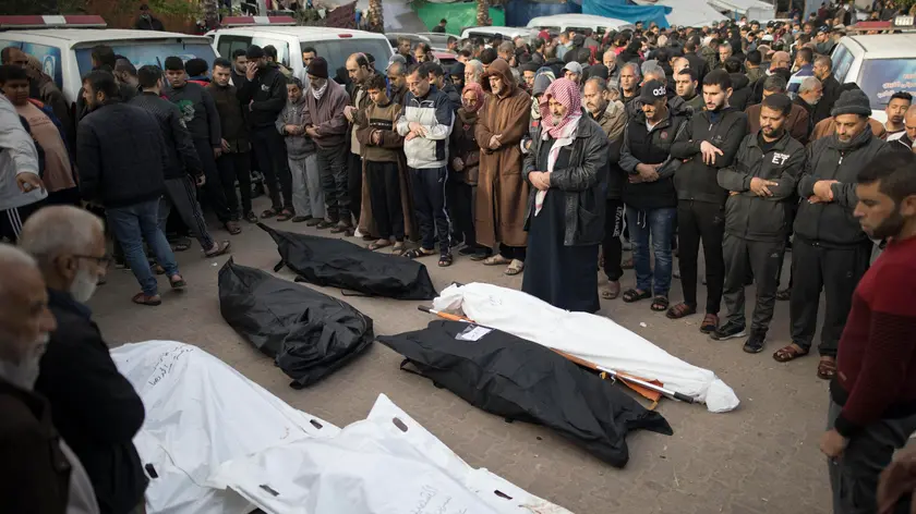 epa11038376 Relatives of Palestinians from the Nassar family, who died during Israeli air strikes in the southern Gaza Strip, pray in front of their wrapped bodies, outside Nasser Hospital in Khan Yunis, southern Gaza Strip, 20 December 2023. Israeli forces resumed military strikes on Gaza after a week-long truce expired on 01 December. More than 18,000 Palestinians and at least 1,200 Israelis have been killed, according to the Palestinian Health Ministry and the Israel Defense Forces (IDF), since Hamas militants launched an attack against Israel from the Gaza Strip on 07 October, and the Israeli operations in Gaza and the West Bank which followed it. EPA/HAITHAM IMAD