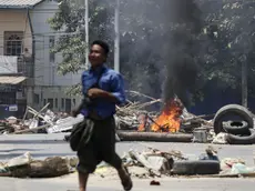 epa09711494 (19/31) (FILE) - A man runs past a burning a roadblock set on fire by military personnel at a railway staff compound during a raid in Yangon, Myanmar, 10 March 2021 (reissued 27 January 2022). On 01 February 2021 the Myanmar Army arrested democratically elected political leaders and seized control of the country. Protests erupted nationwide leading to violent clashes and a military retaliation that had left at least 1,000 dead within the first six months. According to the United Nations, by early December 2021 over 280,000 people were still internally displaced in Myanmar due to armed clashes and insecurity. EPA/STRINGER ATTENTION: This Image is part of a PHOTO SET