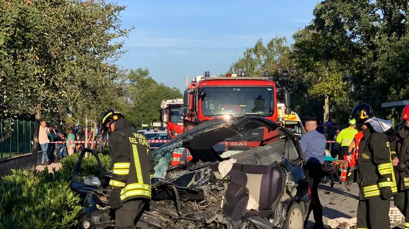 I vigili del fuoco al lavoro e i rottami di una delle due auto coinvolte (foto Ambrosio / Petrussi)