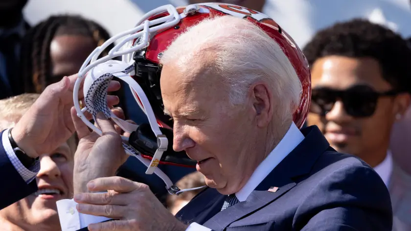 epa11382879 US President Joe Biden takes off a Kansas City Chiefs helmet during a ceremony welcoming the Kansas City Chiefs to the White House to celebrate their championship season and victory in Super Bowl LVIII, on the South Lawn of the White House in Washington, DC, USA, 31 May 2024. EPA/MICHAEL REYNOLDS / POOL