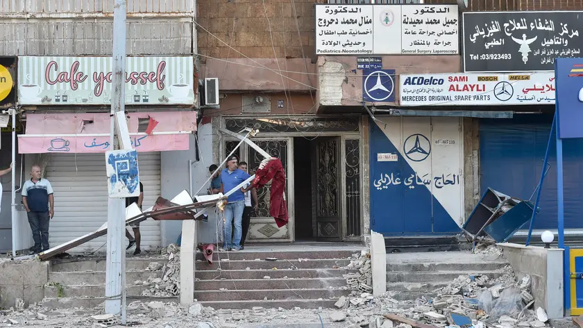 epa11633329 People stand outside a damaged building following overnight Israeli strikes in the Cola area of Beirut, Lebanon, 30 September 2024. The Popular Front for the Liberation of Palestine (PFLP) confirmed that three of its leaders were killed in the strike of an apartment building in Cola at dawn on 30 September.