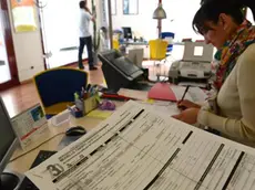 Una ragioniera lavora ad un modello 730 nell'ufficio di un commercialista a Pisa, in una foto di archivio. ANSA / STRINGER