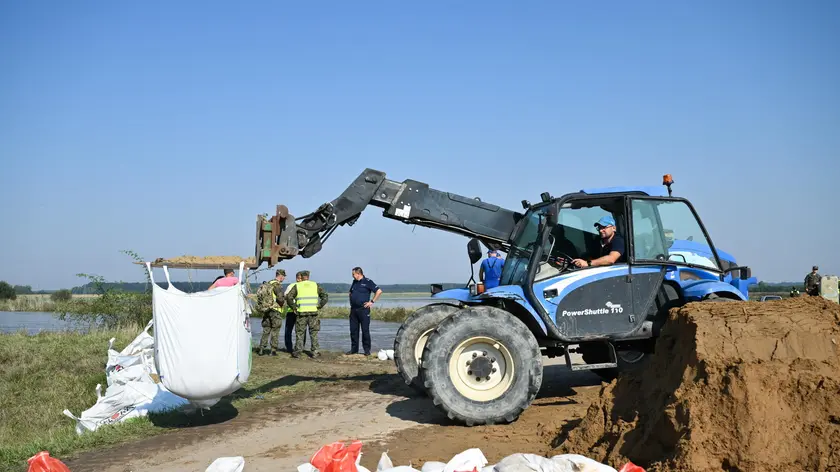 epa11611530 Polish soldiers stand next to an excavator working to reinforce the flood embankments in the village of Marcinkowice, near Olawa, in the Lower Silesian Voivodeship, southwestern Poland, 18 September 2024. Emergency services, such as the fire department and territorial defense forces, are working to reinforce the flood barriers as a flood wave is passing through Olawa. A low-pressure system named Boris brought heavy rain to central Europe between 11 and 15 September? 2024, causing widespread flooding? in central and eastern Europe. EPA/MACIEJ KULCZYNSKI POLAND OUT