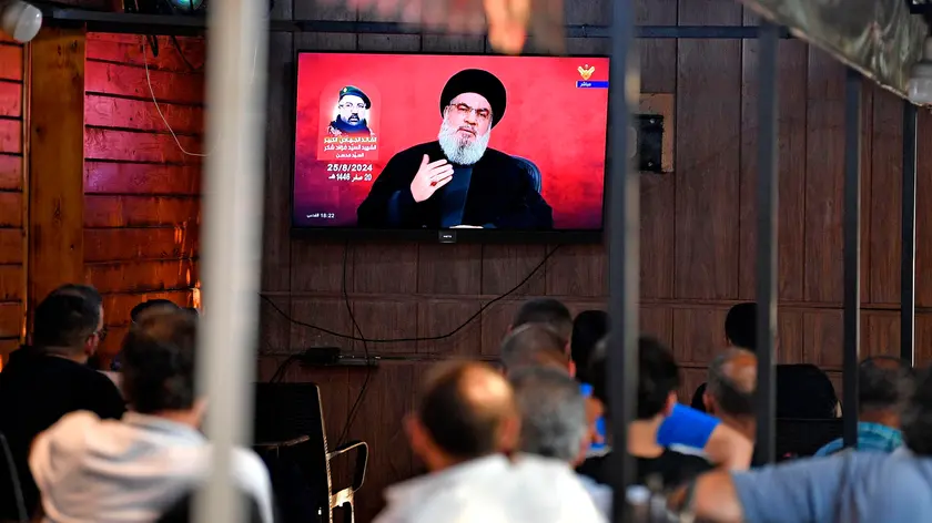 epa11564623 People watch Hezbollah Secretary-General Hassan Nasrallah delivering a televised speech at a coffee shop in the southern suburb of Beirut, Lebanon, 25 August 2024. Hezbollah announced in a statement early on 25 August that the group launched 'an aerial operation with numerous drones' targeting Israeli territory as the 'phase one' of a retaliatory attack for the killing of senior Hezbollah commander Fuad Shukr, on 30 July in Beirut. The Israeli Defense Forces (IDF) said some 100 fighter jets 'struck and destroyed thousands of Hezbollah rocket launcher barrels, aimed for immediate fire toward northern and central Israel'. EPA/ABBAS SALMAN