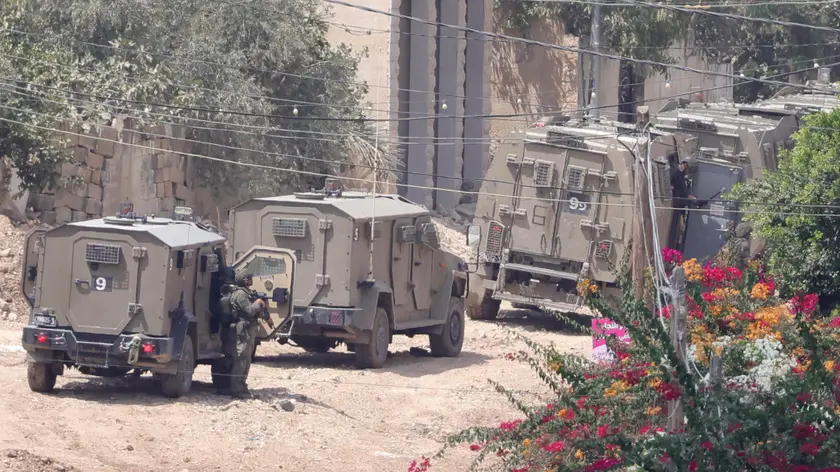 epa11574972 Israeli troops move inside the Jenin refugee camp on the fourth day of an Israeli military operation in the West Bank city of Jenin, 31 August 2024. According to the Palestinian Health Ministry, at least 20 Palestinians have been killed since Israeli military operations started on 28 August 2024 in the West Bank cities of Tulkarem, Jenin and Tubas. The Israeli army said that it's conducting a large-scale counter-terrorism operation in several areas. More than 40,000 Palestinians and over 1,400 Israelis have been killed, according to the Palestinian Health Ministry and the Israel Defense Forces (IDF), since Hamas militants launched an attack against Israel from the Gaza Strip on 07 October 2023, and the Israeli operations in Gaza and the West Bank which followed it. EPA/ALAA BADARNEH