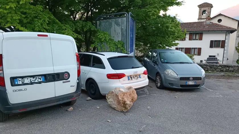 Il masso caduto tra le auto nella parte superiore del parcheggio di via Forame a Tolmezzo