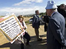 Il proprietario della discarica di Malagrotta, Manlio Cerroni, nell'area di Monti dell'Ortaccio, di fronte a lui una manifestante mostra un cartello contro la discarica, 29 ottobre 2012. ANSA/ MASSIMO PERCOSSI