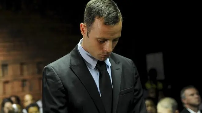 epa03591641 South African paralympian Oscar Pistorius stands in the dock at the Pretoria Magistrate's Court during a break in his bail hearing, South Africa 20 February 2013. Pistorius is accused of murdering his girlfriend Reeva Steenkamp on Valentine's Day. Pistorius has not formally pleaded yet, but has denied the murder allegation in an affidavit, which was read to the court. EPA/STR