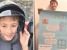 Mattia Cossettini con il casco dei vigili del fuoco e con il suo manifesto di candidatura