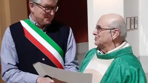 Il commissario Mareschi consegna a monsignor De Tina il riconoscimento a “cittadino benemerito”