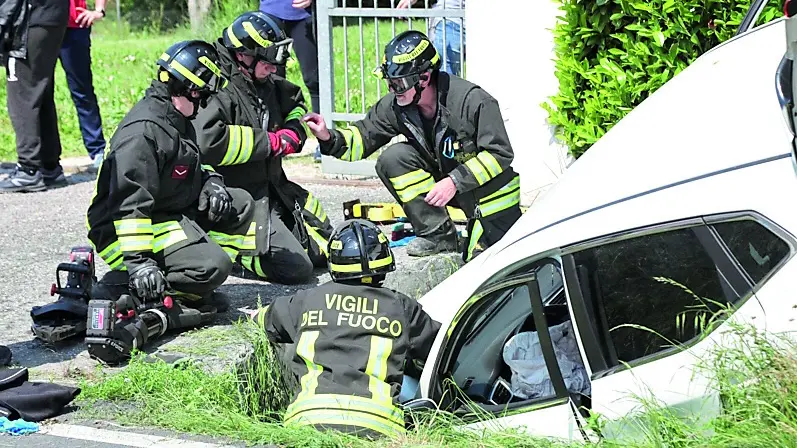 L’auto nel fosso in via Valler ad Azzano Decimo e i soccorritori all’opera (foto Ambrosio/Petrussi)