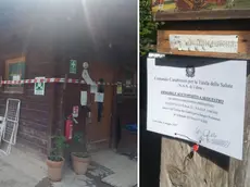 Uno degli chalet sequestrati a Cercivento e l'avviso del provvedimento apposto sulla struttura