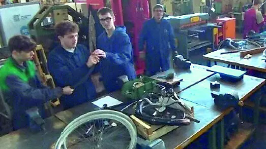 Gli studenti al lavoro sulle vecchie biciclette nel laboratorio della scuola