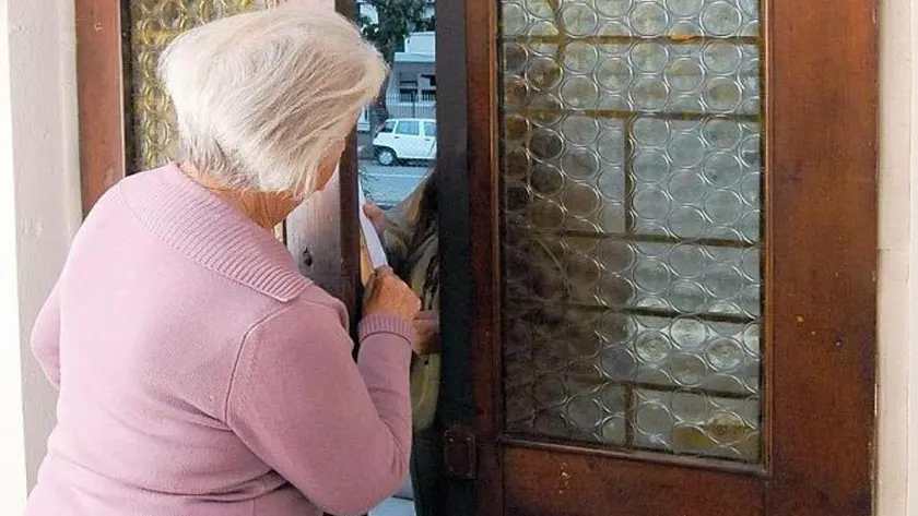 Anziana schiaccia le dita sulla porta di casa a un potenziale truffatore.