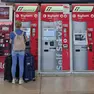 Alle biglietterie automatiche un’utente con bagagli al seguito. Foto di Andrea Lasorte