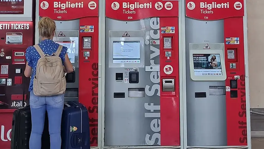 Alle biglietterie automatiche un’utente con bagagli al seguito. Foto di Andrea Lasorte