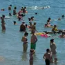 Bagnanti cercano refrigerio in acqua a Trieste. Foto Bruni