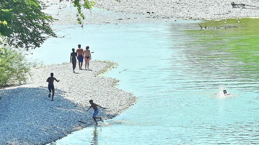 Alcune persone fanno il bagno nel Natisone nonostante il divieto foto petrussi