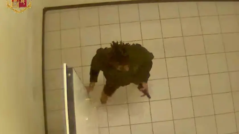 Un’immagine catturata allora dal sistema di videosorveglianza che vede Meran muoversi all’interno della Questura dopo aver ucciso i due agenti