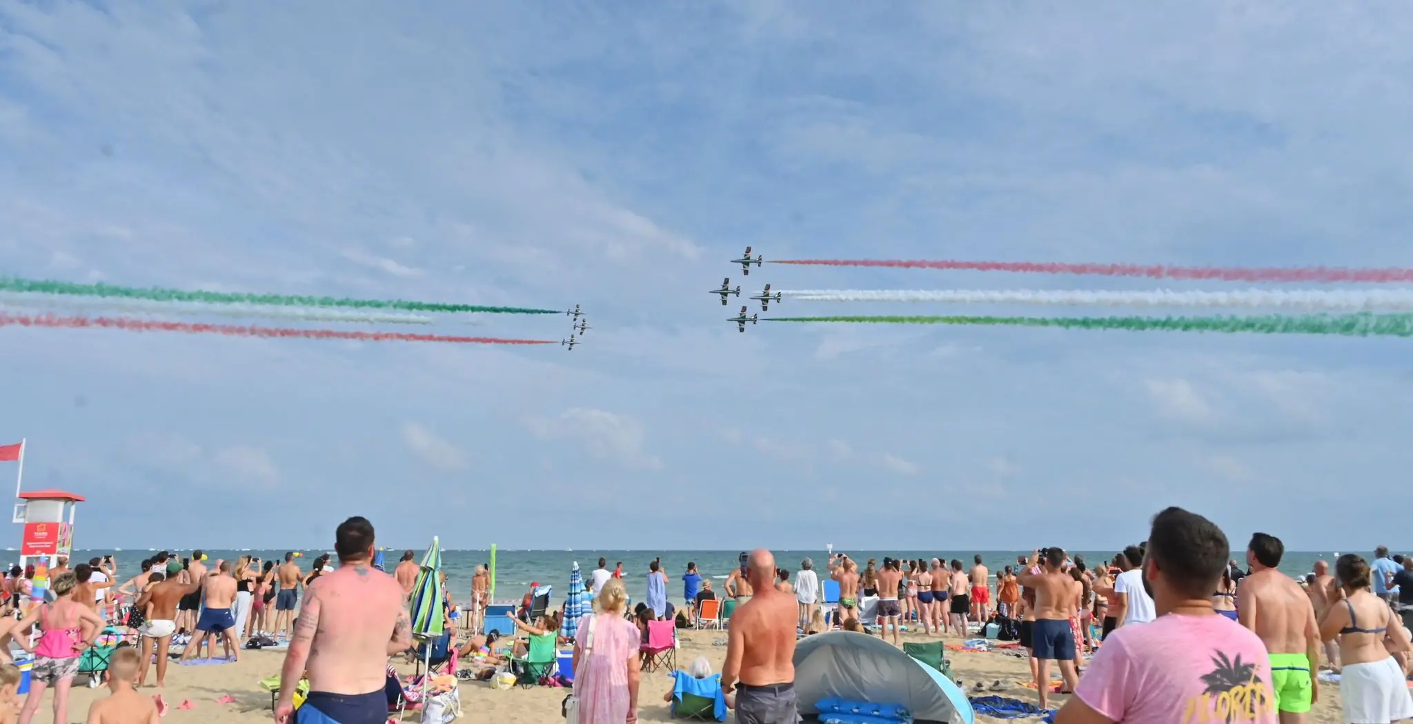 Incerti, fino all'ultimo. Fino a quando il tricolore non ha riempito il cielo di Lignano. L'airshow delle Frecce ha sfidato l'allerta meteo, passata da gialla ad arancione, e ha incantato il litorale friulano. Migliaia le persone con il naso in sù a vedere le acrobazie della Pan