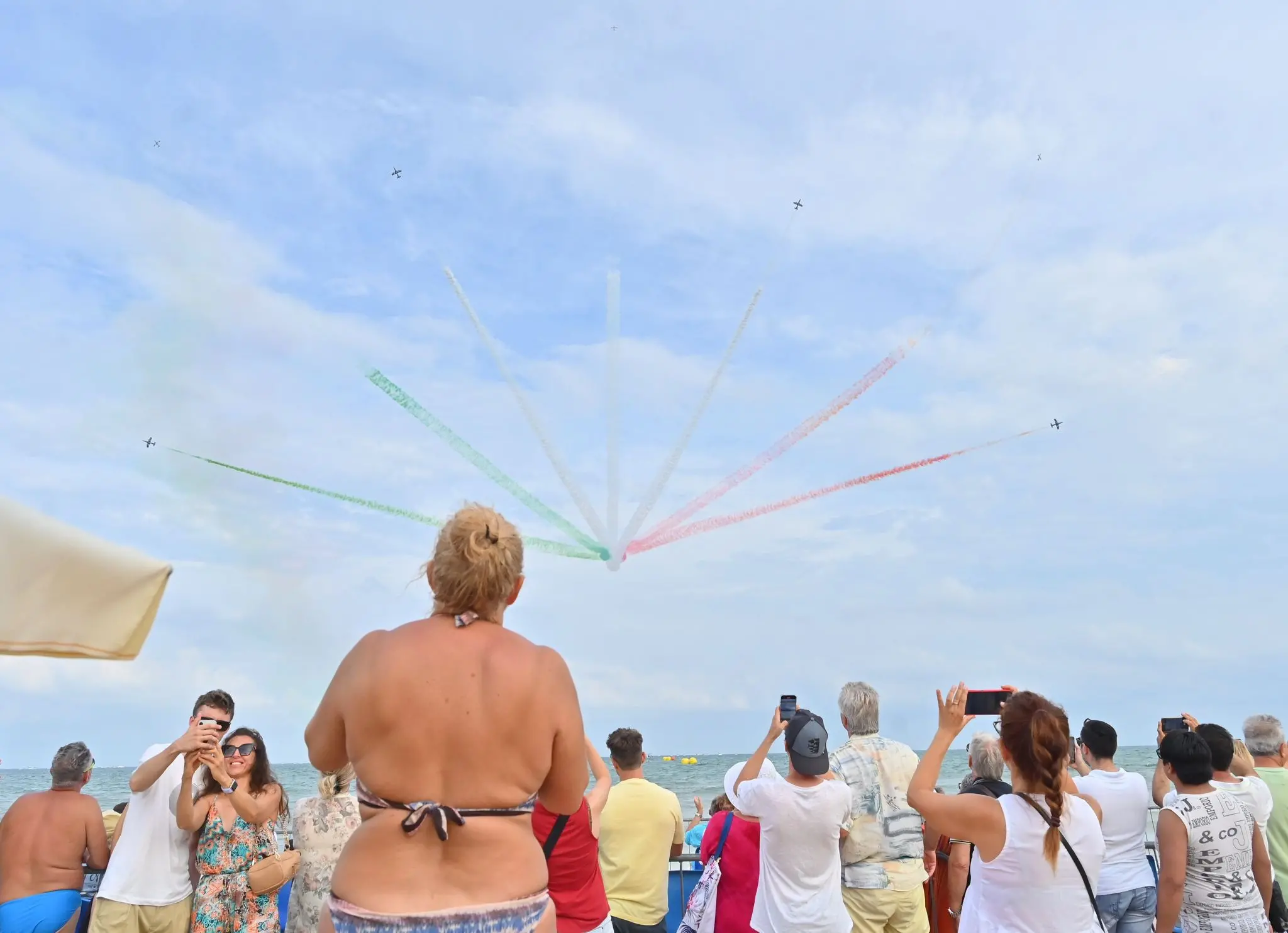 Incerti, fino all'ultimo. Fino a quando il tricolore non ha riempito il cielo di Lignano. L'airshow delle Frecce ha sfidato l'allerta meteo, passata da gialla ad arancione, e ha incantato il litorale friulano. Migliaia le persone con il naso in sù a vedere le acrobazie della Pan