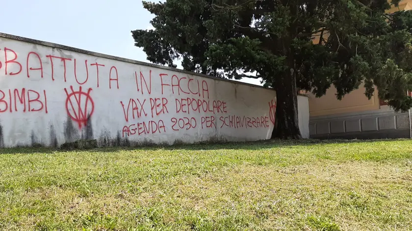 Le scritte no vax con cui è stato imbrattato il muro del cimitero di Feletto Umberto