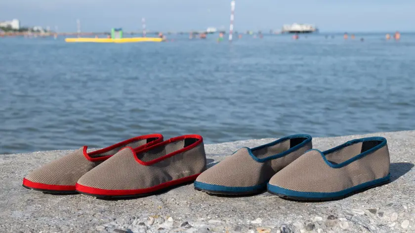 La collaborazione tra RE49 e Lignano Pineta trasforma vecchi teli da spiaggia in scarpe artigianali di design,