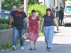 Al centro Lorena Venier, reo confessa dell'omicidio del figlio, mentre viene portata via dalla sua abitazione