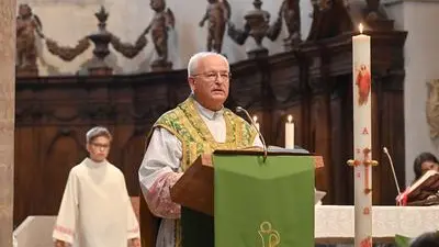 Sopra il parroco di Gemona, monsignor Valentino Costante, durante l’omelia, sotto alcuni dei fedeli presenti domenica alla funzione (foto petrussi)