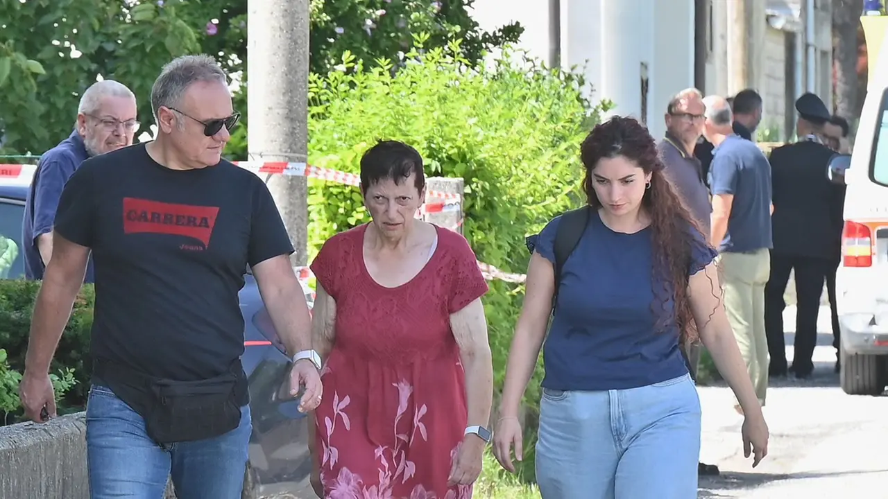 Al centro Lorena Venier, reo confessa dell'omicidio del figlio, mentre viene portata via dalla sua abitazione