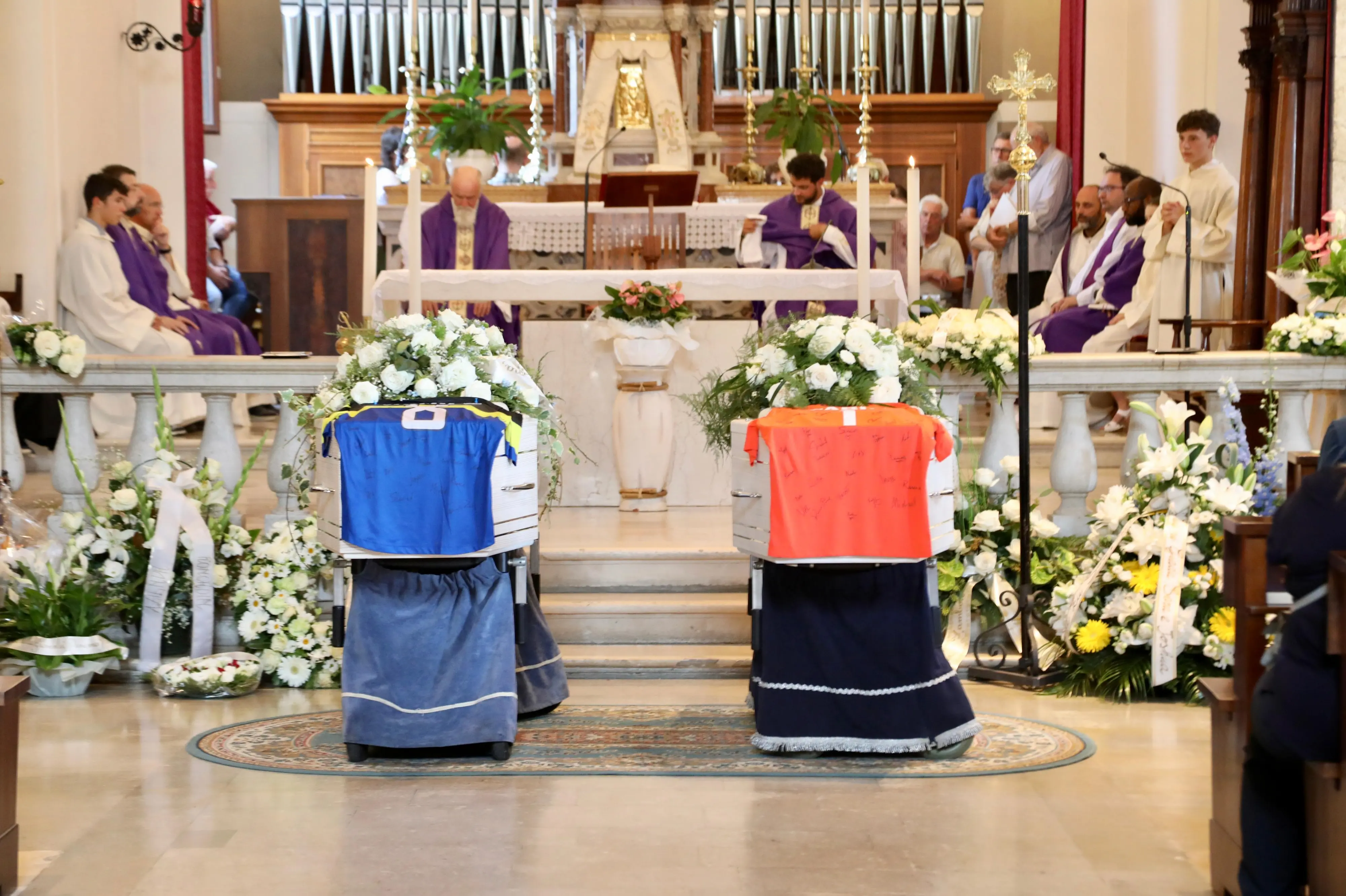 Le maglie con le firme dei compagni di squadra appoggiate sulle bare dei due giovani (foto Petrussi)