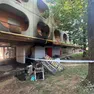 Il materiale incenerito dopo il rogo e i segni dell'incendio sul condominio