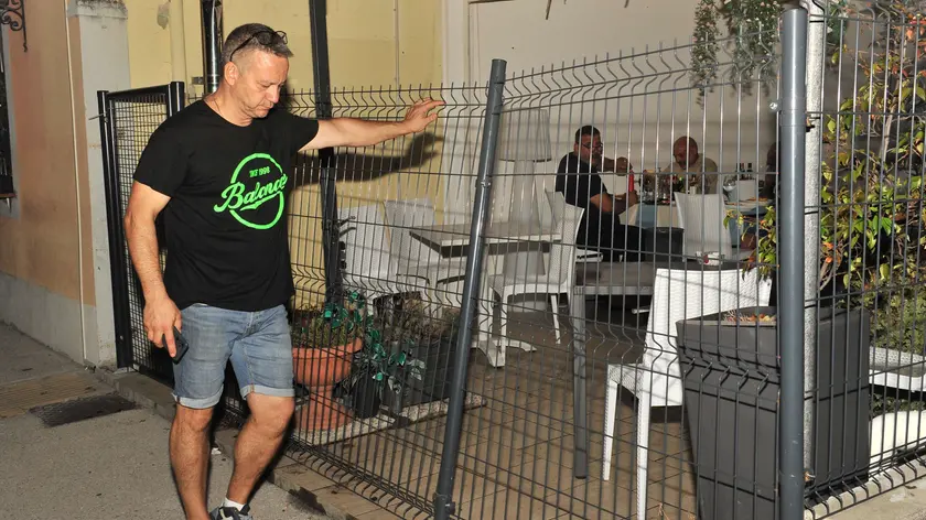 Paolo Pontonutti davanti alla rete del giardino della trattoria Moreale, in via Cividale, dove è avvenuta la lite. I