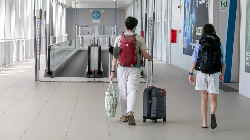 Al Trieste Airport un viaggiatore con trolley e zaino al seguito