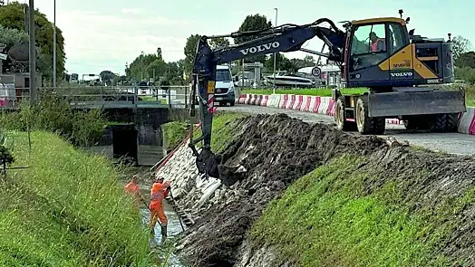 Due momenti dei lavori di ripristino della sponda franata lungo il canale della strada per Lignano