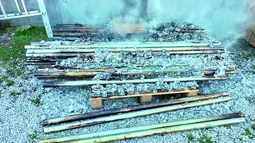 Il materiale ancora fumante dei supporti del tendone andato a fuoco