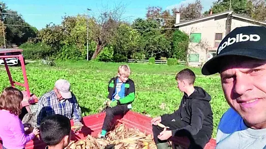 Grandi e piccoli impegnati nella raccolta e nella sgranatura delle pannocchie