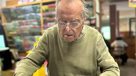 Il novantenne Tarcisio Vidoni mentre sistema i giornali in edicola