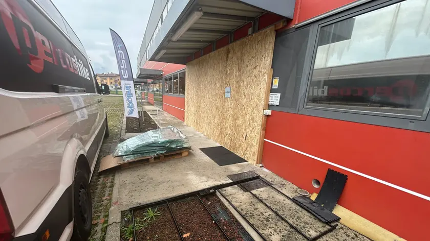 La vetrata in frantumi e la copertura provvisoria all'ingresso del negozio (foto Petrussi)