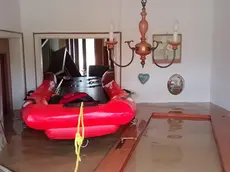 Un gommone dei soccorritori nel soggiorno di una casa allagata a Versa
