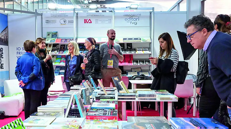 Lo stand degli editori del Fvg e, in alto, l’assessore regionale Anzil con Alberto Frappa Raunceroy