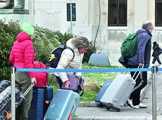 Turisti con le valigie lungo le Rive in centro a Trieste