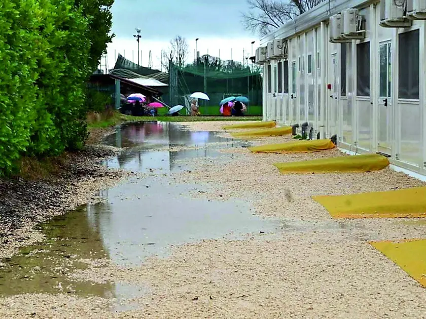 Pozzanghere e fango nell’area dei container della scuola a Roraigrande